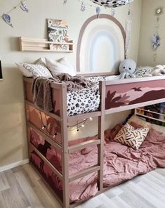 there is a bunk bed with pink sheets and pillows