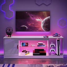 an entertainment center with a large television mounted on it's wall and purple lighting