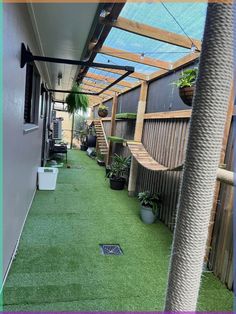 an outdoor area with artificial grass and potted plants