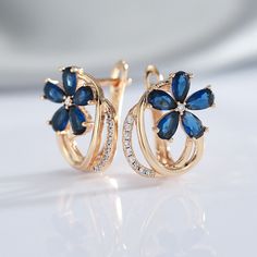 Do you want to show everyone that you're a luxuriously fashionable woman? These Blue Zircon Floral Earrings are exquisitely beautiful earrings that will impress everyone. The blue flower design is a unique style that makes these earrings look very expensive. Buy these for anniversaries, birthdays, holidays, or just because. Specifications: Side Stone: Natural White Zircon Main Stone: Blue Zircon Size: 17mm * 14 mm Metal: 585 (14kt) Gold Vermeil 🚐Delivery: 2-3 weeks Blue Elegant Design Earrings For Anniversary, Blue Flower Shaped Earrings For Formal Occasions, Elegant Flower-shaped Hoop Earrings For Anniversary, Blue Flower-shaped Formal Earrings, Formal Blue Flower-shaped Earrings, Blue Formal Flower-shaped Earrings, Elegant Flower Hoop Earrings For Anniversary, Blue Cubic Zirconia Earrings With Elegant Design, Elegant Blue Flower Earrings