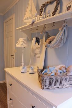 a white dresser topped with lots of stuffed animals next to a shelf filled with toys