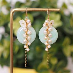 >> Like my design? Follow me on Instagram to stay updated on new arrivals and special discounts http://instagram.com/faithanddeedsjewelry Graceful and romantic. These beautiful earrings are made with Type A Burmese jade donuts in light green colour, dressed with dainty white flower cabochon made with mother of pearl and cluster of fresh water pearls that flow gracefully from top of the jade to create a very elegant cascade. A simple yet elegant design for the romantic at heart. Jade donuts Round Jade Earrings For Wedding, Jade Round Earrings For Wedding, Elegant Round Jade Earrings For Weddings, Donut Earrings, Donuts Earrings, Burmese Jade, Pearl Cluster, Earrings Pearl, Water Pearls