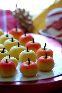 several apples are arranged on a plate with toothpicks in the shape of an apple