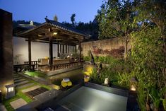 an outdoor area with a small pool at night