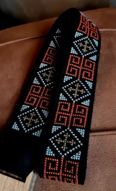 a pair of black and orange knitted headbands sitting on top of a couch