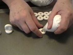 a person is using an object to make something out of white buttons on a table