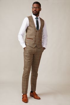 Inspired by old age country wear, the DX7 suit remains an ever so popular style, reminiscent of the 18th century. It is ideal for Autumn/Winter with its earthy colour palette and heavy fabric. A touch of modernism is added with a velvet contrast collar, elbow pads and pocket trims, nudging it back into the 21st century. Perfect for a rustic countryside wedding. Mix-and-match the waistcoat to differentiate from the groomsmen and match your accessories with the bridesmaid dresses. Looking for a pl Classic Brown Double Breasted Suit For Winter, Winter Tweed Three-piece Suit For Work, Fitted Brown Suit, Tailored Brown Vest With Notch Lapel, Semi-formal Winter Tweed Three-piece Suit, Winter Semi-formal Tweed Three-piece Suit, Fitted Single-breasted Tweed Vest, Tailored Tweed Three-piece Suit For Winter, Winter Tailored Tweed Three-piece Suit