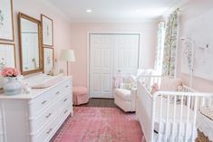 a baby's room with pink carpet, white crib and floral wallpaper