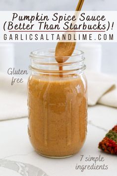 pumpkin spice sauce in a glass jar with a wooden spoon sticking out of the top