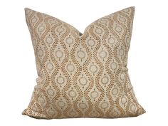 a tan and white pillow with an intricate design on the front, sitting on a white background