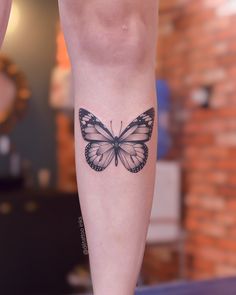 a woman's leg with a butterfly tattoo on the left side of her calf