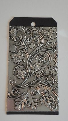 a metal tag with an ornate design on it