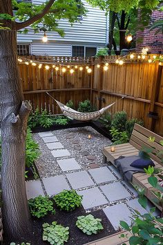 a small backyard with a hammock and tree