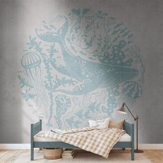 a room with a bed, lamp and wallpaper on the walls that has an artistic design