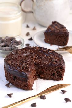 a piece of chocolate cake on a plate with a knife and fork next to it