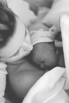 a black and white photo of a baby wrapped in a blanket