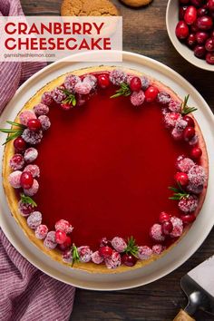 cranberry cheesecake on a white plate with red berries