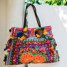 "This charming tote bag for lazy days at the beach and wandering around. It is made with an amazing piece of fabric woven by the HMONG hill tribes of Lanna Region (Northern Thailand). It features cotton lining, leather straps, a zipper closure and adorned with colorful hairs, pom poms. This bag will enhance your appearance. We buy materials from Hmong market and we design and sew by hand. Some of the bags we modify to improve the product. The Hmong tribes live in the North of Thailand and have o Bohemian Beach Bag For Beach Season Travel, Bohemian Beach Bag For Travel And Beach Season, Bohemian Beach Bag For Travel During Beach Season, Bohemian Beach Bag For Beach Season, Bohemian Tote Beach Bag For Travel, Bohemian Beach Tote Bag For Travel, Bohemian Shoulder Bag For Beach Travel, Bohemian Shoulder Bag For Beach Season Travel, Vibrant Beach Bags