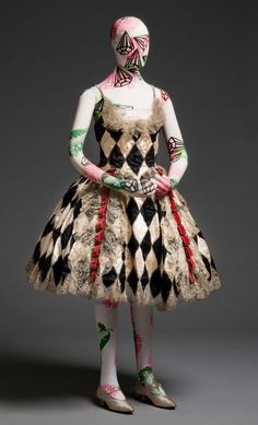 a mannequin dressed in an elaborate dress with painted face and body art on it