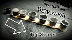 a row of cups sitting next to each other on top of a wooden tray with the words new formula gray wash