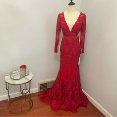 a mannequin is dressed in a red gown