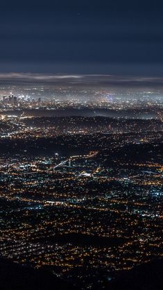 an aerial view of the city lights at night from high up in the sky,