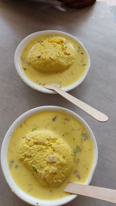 two bowls of soup with spoons on a table