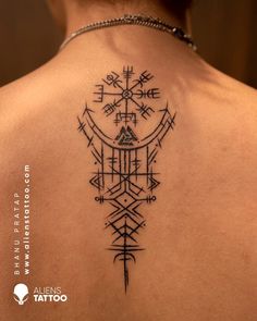 the back of a woman's neck with an arrow and compass tattoo on it