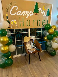 a welcome to camp horner sign and balloons in front of a window with a chair