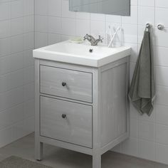 a white sink sitting under a bathroom mirror