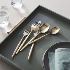 there are four forks and two spoons on the tray