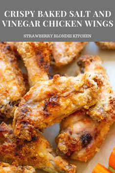 crispy baked salt and vinegar chicken wings on a cutting board with carrots in the background