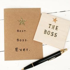 the best boss ever card and pen on a white wooden table with a notepad