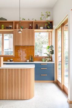 a kitchen with wooden cabinets and blue counter tops in front of large open windowed windows