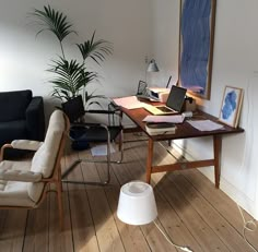 a living room filled with furniture and a laptop computer on top of a wooden table