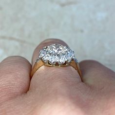 a close up of a person's hand holding a diamond ring