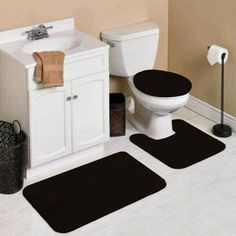 three bathroom rugs in front of a toilet and sink