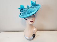 "Vintage Style Aquamarine Blue Velvet Fascinator Hat with Bow & Blusher Veil     12\" wide * 11\" across * 4\" tall Aquamarine blue velvet fascinator hat with matching net blusher veil, dyed to match feathers and whimsical bows on top. Complete with your choice of a matching satin headband or silver alligator clip, both easily slide into an elastic fitting inside. Excellent Condition ~ New, never worn" Fitted Blue Brimmed Top Hat, Blue Vintage Fascinator For Party, Vintage Blue Fascinator For Weddings, Vintage Blue Party Hat, Blue Costume Hat For Church, Vintage Blue Hat For Evening, Blue Vintage Hat For Evening, Blue Costume Hats And Headpieces For Church, Blue Fitted Mini Hat For Church