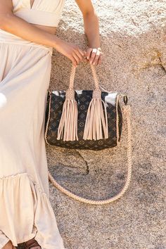 This iconic bag has an unmistakable shape and unites timeless design with our heritage details while being lightweight and very roomy. Tailor-made and hand-braided natural cowhide trim and rolled comfortable handles slip easily over the arm, with a detachable shoulder or cross body strap for the epitome of a classic made Boho-chic and more comfortable. Dimensions: Width: 11.8" Depth: 7” Strap Length: 47" Strap Type: Wide Round Braided, Interchangeable Handle Type: Round Braided Guarantee Of Auth Luxury Satchel With Braided Handles For Travel, Chic Handheld Satchel With Braided Handles, Luxury Straw Bag With Handle Drop For Travel, On-the-go Hobo Bag With Braided Handles, Leather Straw Tote Bag With Detachable Strap, Leather Shoulder Bag With Braided Handles, Luxury Satchel With Braided Double Handles, On-the-go Satchel Shoulder Bag With Braided Handles, Top Handle Bag With Braided Handles For On-the-go