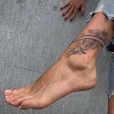 a woman's foot with a flower tattoo on her left side and the bottom part of her leg