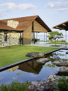 the house is surrounded by large rocks and water