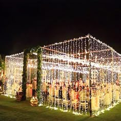 people are standing outside in front of a house covered with christmas lights