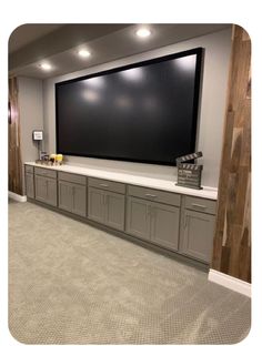 a large flat screen tv mounted to the side of a wall in a home theater