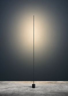 a light that is on top of a pole in the middle of an empty room