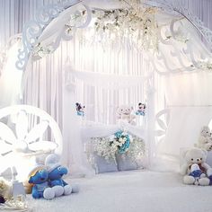 a white canopy bed with teddy bears and flowers