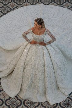 a woman in a wedding dress laying on the floor with her arms behind her back