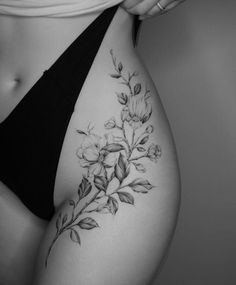 a black and white photo of a woman's stomach with flowers on the side