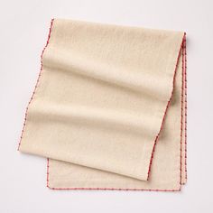 two pieces of cloth sitting on top of each other with red stitching around the edges