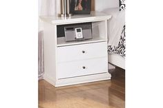 a white nightstand with a phone on it