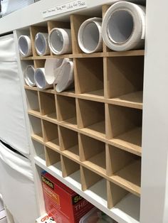 a white refrigerator freezer sitting next to a shelf filled with cups and saucers